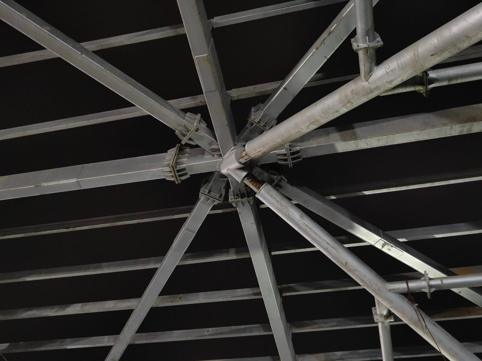 Steel roof framing and diagonal bracing viewed from below at Surat railway station